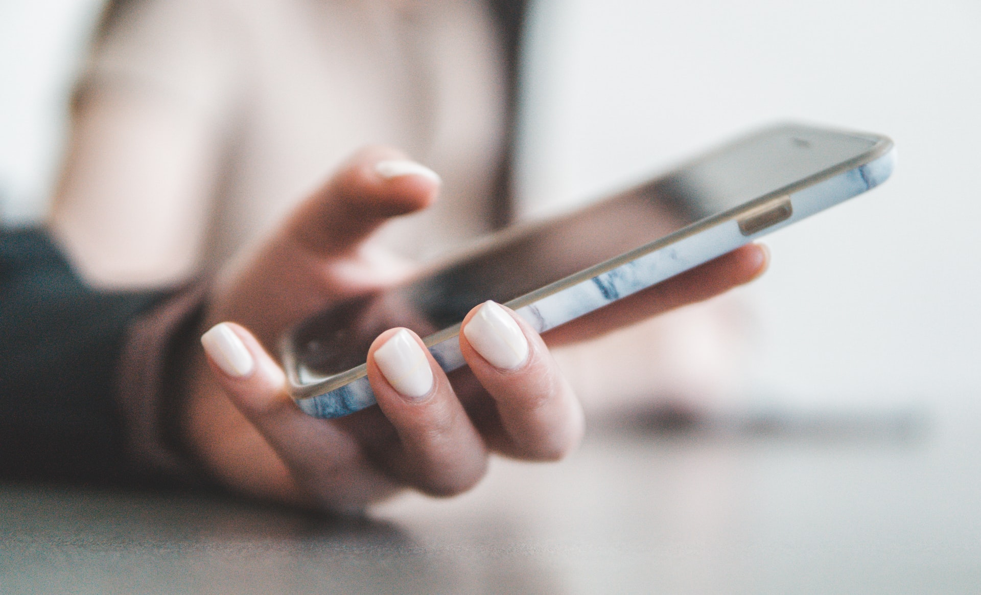 A woman’s hand holding a smartphone